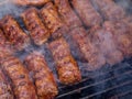 Minced meat rolls or mici cooking on barbecue traditional romanain balkan ottoman dish 1st of may labor day celebration