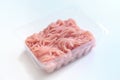 Minced meat in a transparent plastic container. Fresh pork minced meat, on white background. Royalty Free Stock Photo