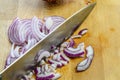 Mincing Red Onions on a wooden cutting board with kitchen knife close up Royalty Free Stock Photo