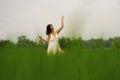 Mind and body connection with nature - middle aged attractive and happy Asian Chinese woman in Summer dress enjoying idyllic Royalty Free Stock Photo
