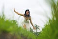 Mind and body connection with nature - middle aged attractive and happy Asian Korean woman in Summer dress enjoying idyllic