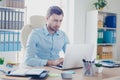 Minded confused boss is using the computer, typing to his colleagues and tying to find the way out from his problem at work