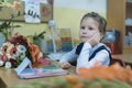 A minded schoolgirl of primary classes sits at a desk and listens to a lesson Royalty Free Stock Photo