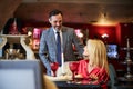 Caring man assisting his lady with a restaurant seat Royalty Free Stock Photo