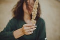 Mindfulness. Carefree hipster girl with windy hair holding herb on beach. Stylish tanned boho woman in modern outfit relaxing on