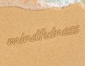 Mindfulness concept, mindful living, text written on the sand of beach Royalty Free Stock Photo