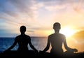 Couple doing yoga in lotus pose over sea sunset Royalty Free Stock Photo