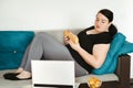 Woman eating unhealthy food watching series online Royalty Free Stock Photo