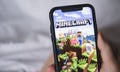 Minecraft game on the iPhone screen in hand.