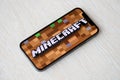 Minecraft mobile iOS game on iPhone 15 smartphone screen on wooden table during mobile gameplay