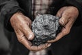 Miner dirty hands holding piece of fossil lignite coal mine