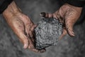 Miner dirty hands holding piece of fossil lignite coal mine