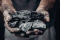 Miner holds coal, palm texture. Concept mining, black stone.