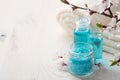 Mineral bath salts, shower gel, towels and flowers on the wooden table Royalty Free Stock Photo