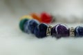 Mineral Chakra color luck fortune stone bracelet on white wool background.