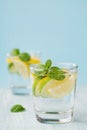 Mineral infused water with limes, lemons, ice and mint leaves on blue background, homemade detox soda water Royalty Free Stock Photo
