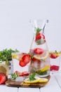 Mineral infused water with strawberry, ice, herb and mint leaves on white background