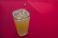 Mineral orangeade in a cubic glass, on a red background Royalty Free Stock Photo