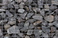 Mineral stones lie behind a metal grate. Wall of stones Royalty Free Stock Photo