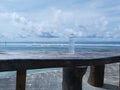 mineral water in a plastic bottle, on a wooden table, beach background and white clouds in a bright and beautiful blue sky