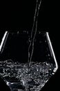 Mineral water is poured into a glass. Black background Royalty Free Stock Photo