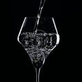 Mineral water is poured into a glass. Black background Royalty Free Stock Photo