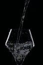 Mineral water is poured into a glass. Black background Royalty Free Stock Photo