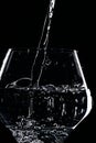 Mineral water is poured into a glass. Black background Royalty Free Stock Photo