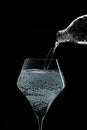 Mineral water is poured into a glass. Black background Royalty Free Stock Photo