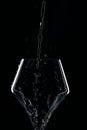 Mineral water is poured into a glass. Black background. Royalty Free Stock Photo