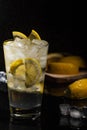 Mineral water with sliced lemon, ice cubes and water splash on black background horizontal view Royalty Free Stock Photo