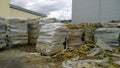 Mineral wool waste in plastic wrap outside. Territory of old abandoned factory. Pile of rubbish. Mess. Substandard. Construction a