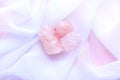 Minerals of gemstones on a pink background. Rough stones and tumbled rose quartz on a white transparent fabric