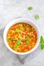 Minestrone soup of fresh vegetables and pasta in a bowl on a gray concrete background. Vegan dish. Copy space Royalty Free Stock Photo