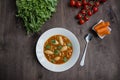 Minestrone soup with pasta and herbs. Italian Cuisine. Dark wooden background. Place for text