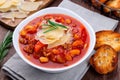 Minestrone soup served with crispy bread, on wooden background, horizontal, closeup Royalty Free Stock Photo