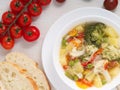 Minestrone soup. Vegetable soup with tomato, celery, carrot, zucchini, onion, pepper, broccoli. Top view, close-up Royalty Free Stock Photo