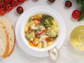 Minestrone soup. Vegetable soup with tomato, celery, carrot, zucchini, onion, pepper, broccoli. Top view, white backdrop Royalty Free Stock Photo