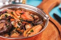 Minestrone stew soup with mushrooms, fish meat, squids, mussels, greens, tomatoes and shrimps Royalty Free Stock Photo