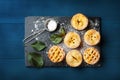 Mini apple pies decorated sugar powder on blue table from above. Delicious autumn pastry dessert.