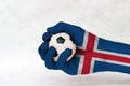 Mini ball of football in Iceland flag painted hand on white background. Concept of sport or the game in handle or minor matter.