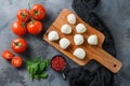 Mini balls of mozzarella cheese, on chop wood board ingredients for salad Caprese. over grey background. Top view Royalty Free Stock Photo