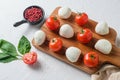 Mini balls of mozzarella cheese, on chop wood board ingredients for salad Caprese. over white background. close up