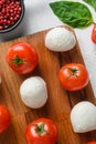 Mini balls of mozzarella cheese, on chop wood board ingredients for salad Caprese. over white background. close up selective focus