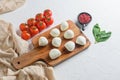 Mini balls of mozzarella cheese, on chop wood board ingredients for salad Caprese. over white background. Top view Royalty Free Stock Photo