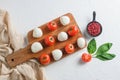 Mini balls of mozzarella cheese, on chop wood board ingredients for salad Caprese. over white background. Top view Royalty Free Stock Photo