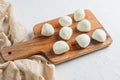 Mini balls of mozzarella cheese, on chop wood board ingredients for salad Caprese. over white background. Top view Royalty Free Stock Photo