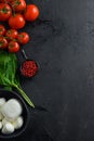 Mini balls of mozzarella cheese,Fresh cherry tomatoes, basil leaf, cheese for caprese salad on black slate stone chalkboard with
