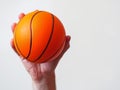 Mini basketball in a hand on a bright background