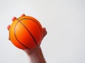 Mini basketball in a hand on a bright background
